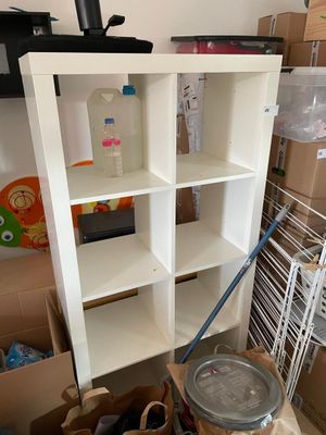 a white bookcase with a lot of boxes on the floor