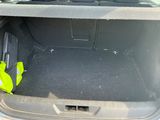 the back of a car with the trunk open and a yellow bag in the trunk
