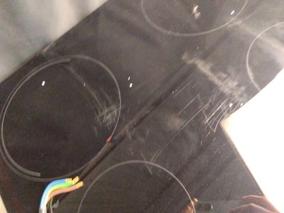 une personne tenant une brosse à dents devant une cuisinière électrique