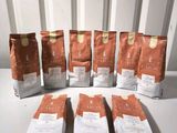 six bags of coffee sitting on a table next to each other