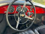 le volant et le tableau de bord d'une voiture rouge équipée de sièges en cuir noir