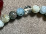 a picture of a beaded bracelet with a red heart on it