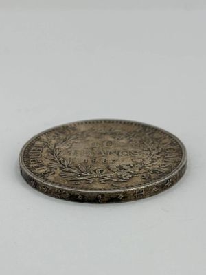 gros plan d'une pièce d'argent sur une surface blanche