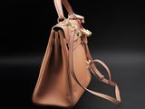 a brown handbag on a black surface with a black background