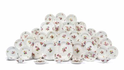 une pile d'assiettes ornées de fleurs, posées sur une surface blanche