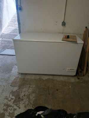 a white chest freezer sitting in the corner of a room
