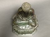 silver statue of a person sitting on a base with a ball on top of it
