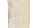 an old book sitting on top of a white surface