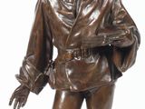 une statue en bronze représentant un homme coiffé d'un haut-de-forme et muni d'une canne