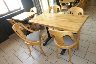 des tables et des chaises dans un restaurant au sol carrelé et doté de fenêtres