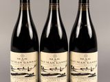 trois bouteilles de vin posées sur une table l'une à côté de l'autre