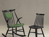 deux fauteuils à bascule noirs avec des coussins verts sur fond gris