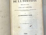 un livre ouvert posé sur une table à côté d'une feuille de papier