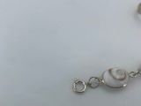 a close up of a bracelet on a table with a white background