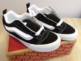 black and white vans slip ons on a box on a wooden table