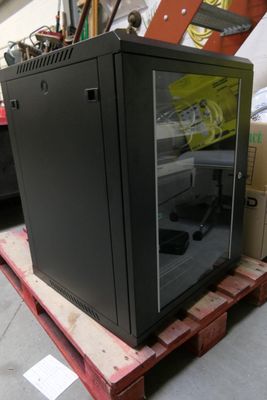 a black cabinet sitting on top of a pallet in a warehouse