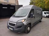 La camionnette grise est garée sur le parking à côté de l'immeuble.