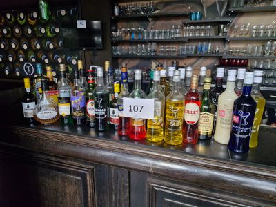 bottles of alcohol are lined up on a bar counter in a bar
