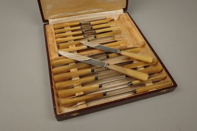 plusieurs couteaux dans un coffret en bois posé sur une table