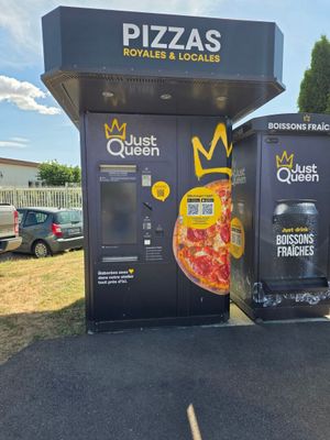 deux distributeurs automatiques proposant des pizzas, installés sur un parking