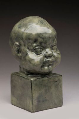 a bronze head of a baby on a square base