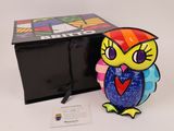 brightly colored owl figurine in front of a black box