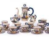 many cups and saucers and a teapot on the table