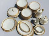 a lot of white and gold plates and cups