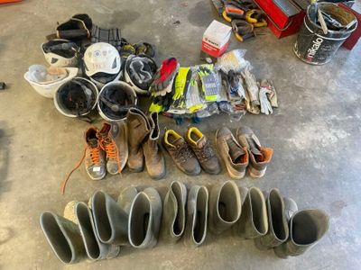 Plusieurs paires de chaussures sont alignées sur le sol d'un garage.