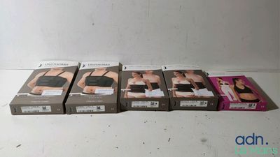 Quatre boîtes de soutiens-gorge sont alignées sur une surface blanche