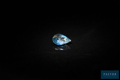 a blue diamond on a black surface in the dark