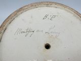 a close up of a white clock with writing on it