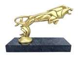 statue of a gold panther on a marble base on a white background