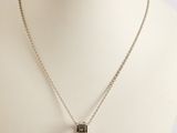 silver necklace with a square shaped pendant on a silver chain