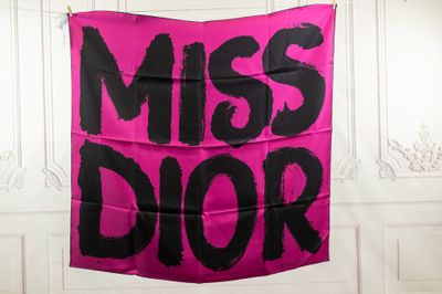 pink and black miss dior banner hanging from a white wall