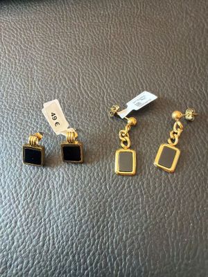 trois paires de boucles d'oreilles posées sur un support en cuir noir