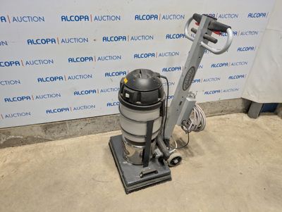 the vacuum is sitting on the floor in front of the wall