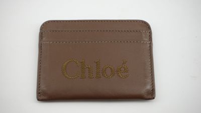 un portefeuille en cuir marron sur lequel est inscrit le mot « Chloé »