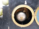 a close up of a clock with a bell on it