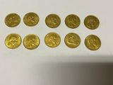 a group of gold coins sitting on top of a white table