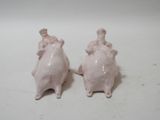 two figurines of mice sitting on a white surface