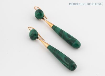 a pair of green and gold earrings on a white surface