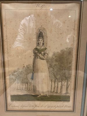 a framed picture of a woman in a dress and hat