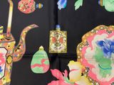 a black table cloth with a picture of a teapot, teapots, and other items on it