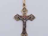 a gold cross with a red stone on it