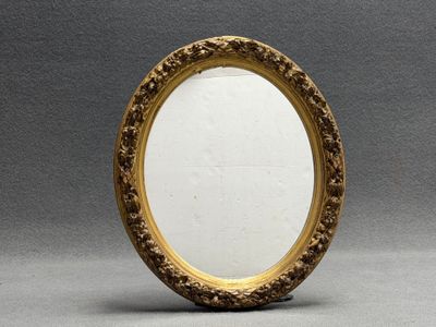 Miroir, cadre ovale en bois et stuc doré de style Régence.