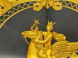 a gold statue of a man riding a horse with a winged horse