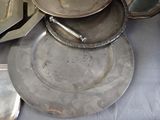 a lot of silver plates and pans on a table