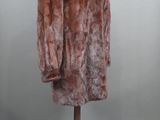 a brown fur coat on a mannequin stand on a grey background