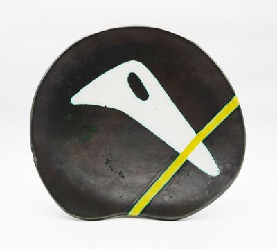 une assiette noire ornée d'un motif blanc et jaune